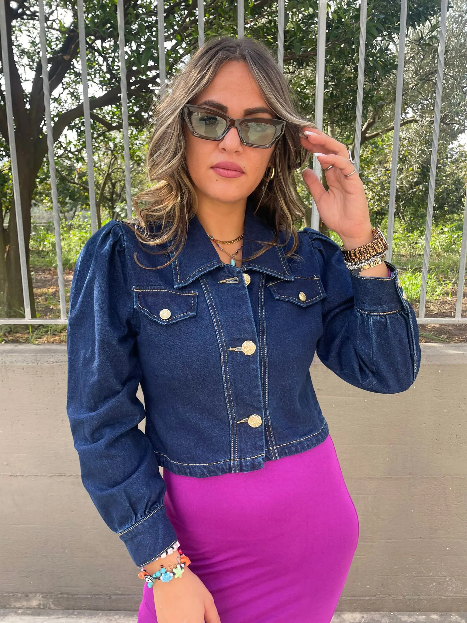 Denim jacket with puffed shoulders and gold buttons.