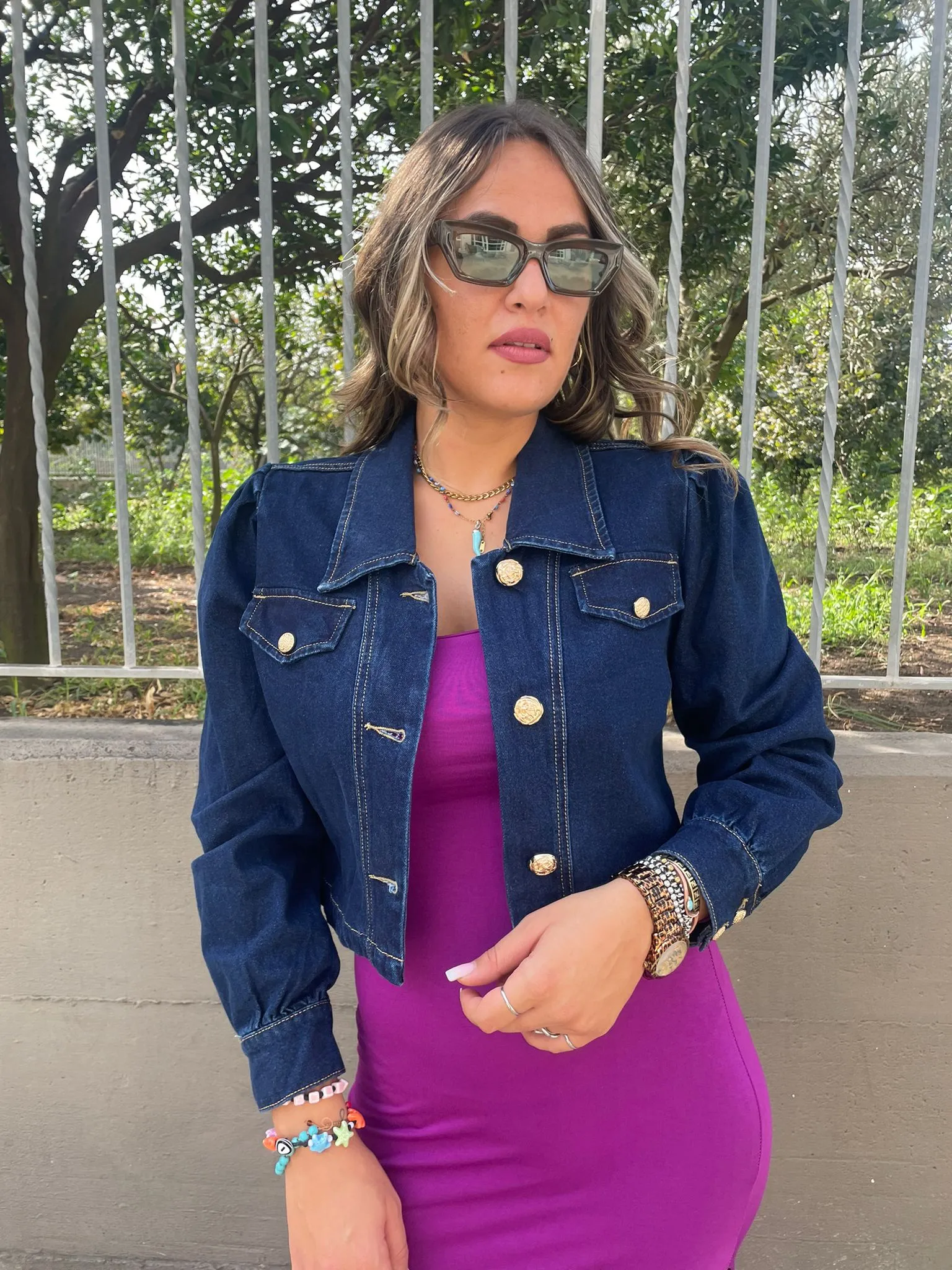 Denim jacket with puffed shoulders and gold buttons.