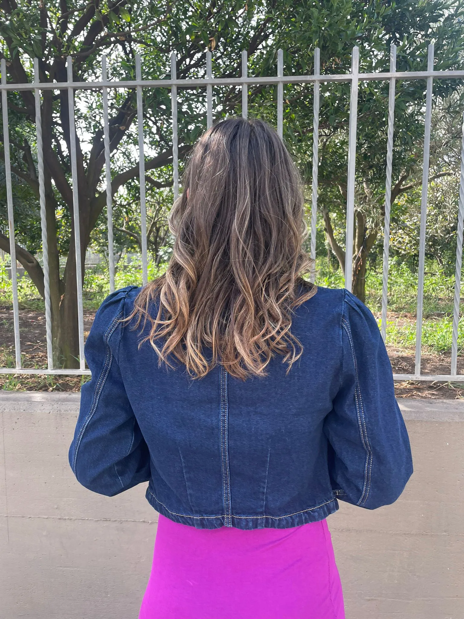 Denim jacket with puffed shoulders and gold buttons.