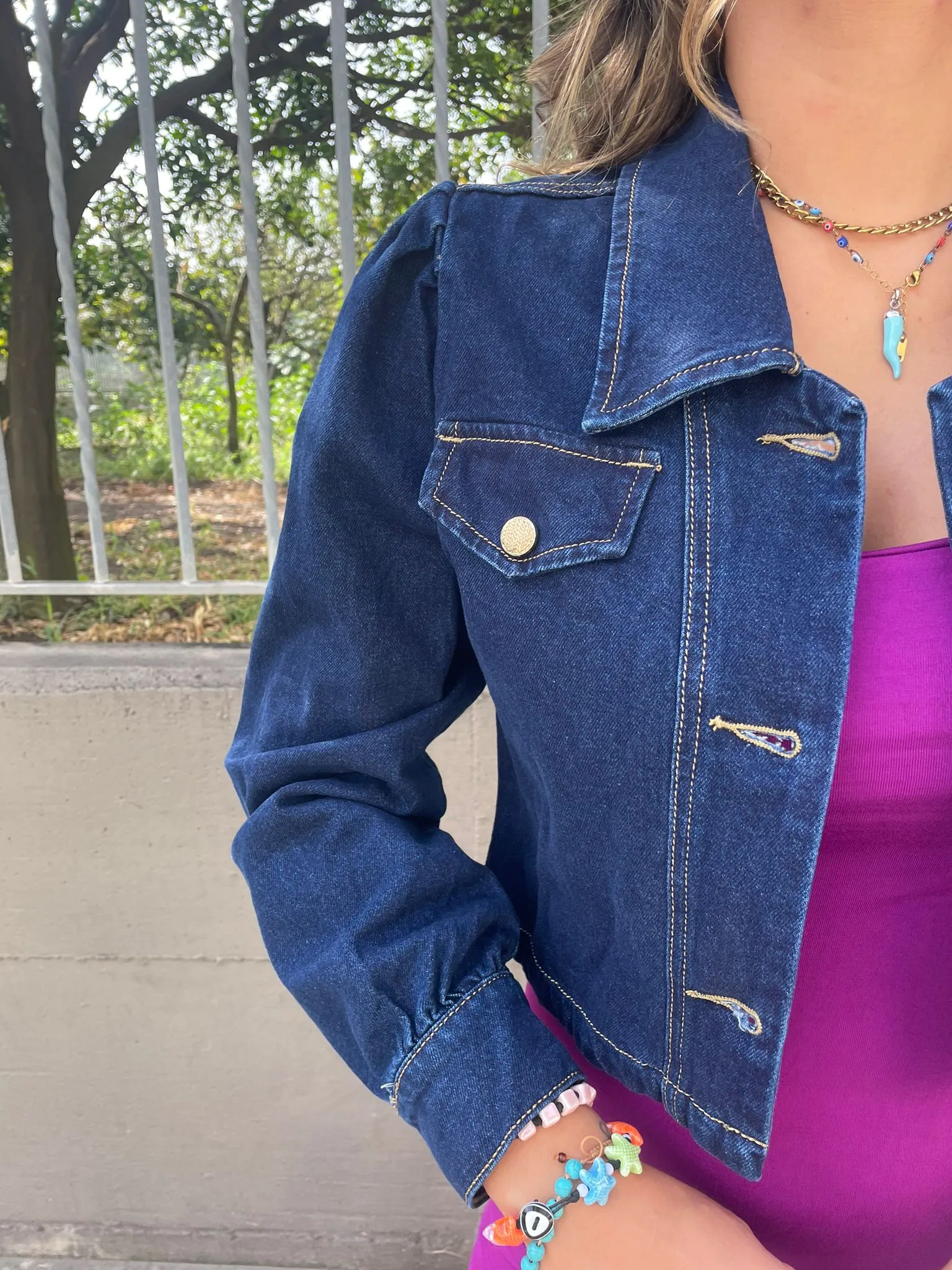 Denim jacket with puffed shoulders and gold buttons.