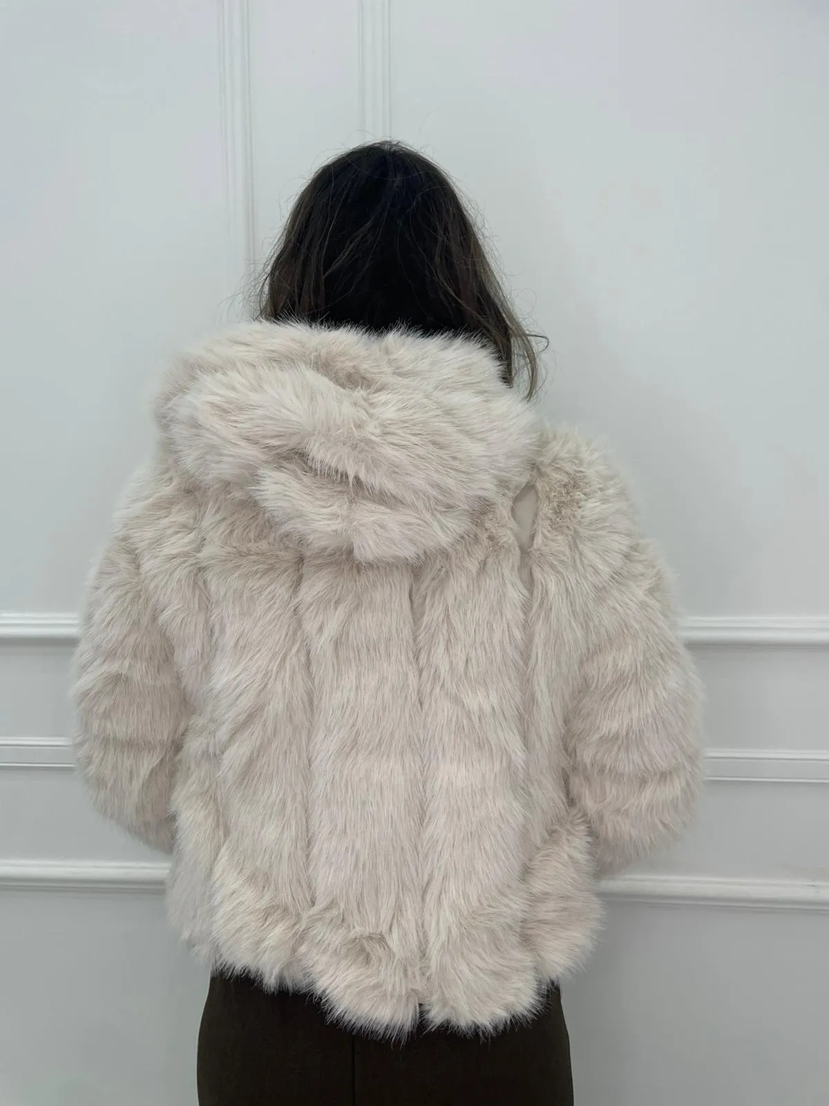 Solid color eco fur coat with patches and hood.